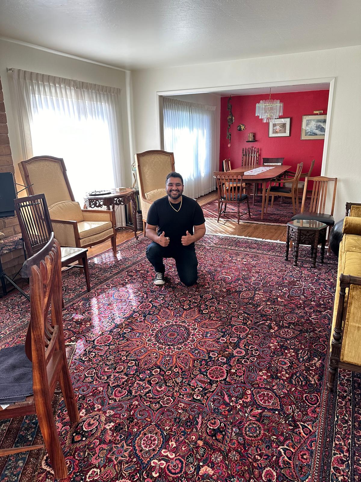 Gaurav Sharma with a large Persian rug in a Bay Area client home